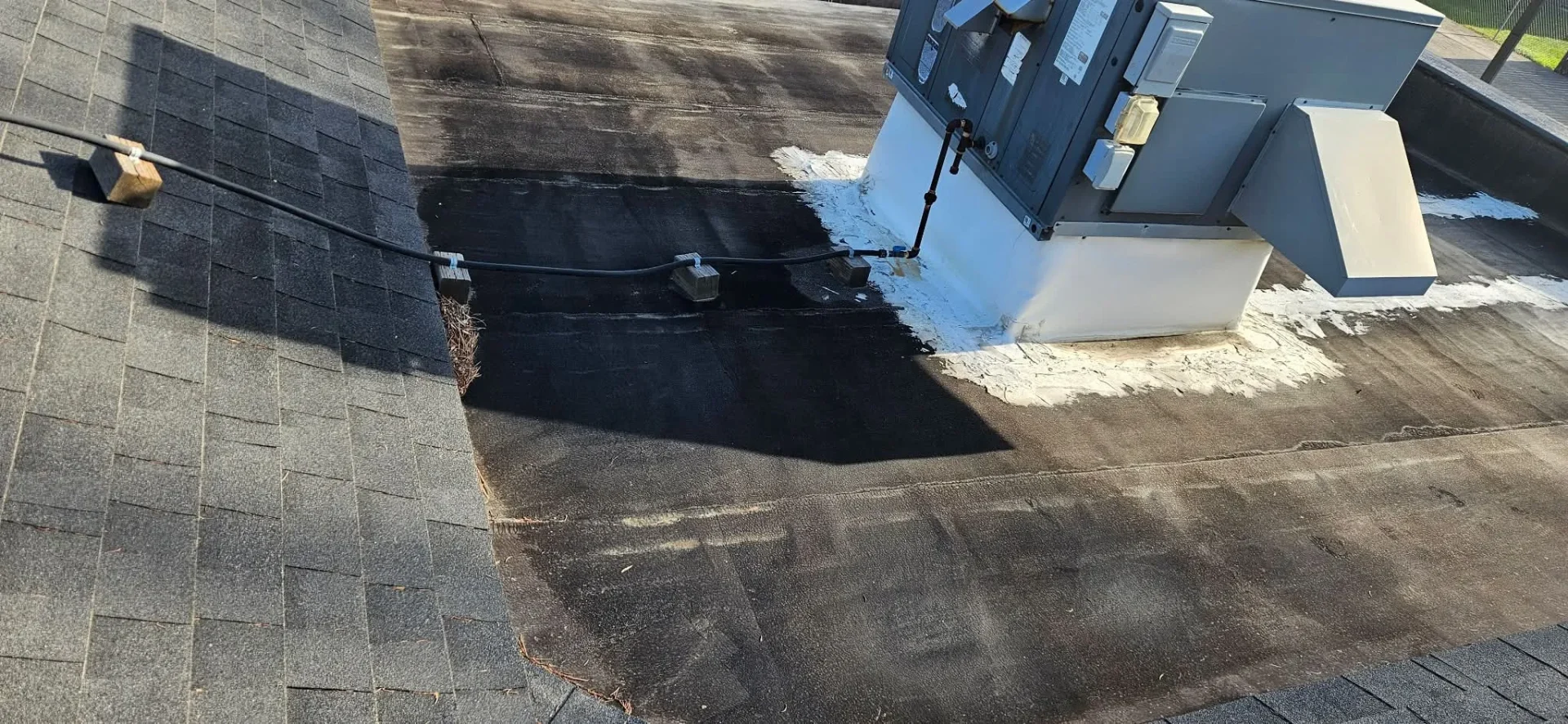 Flat roof before restoration — worn membrane with patching