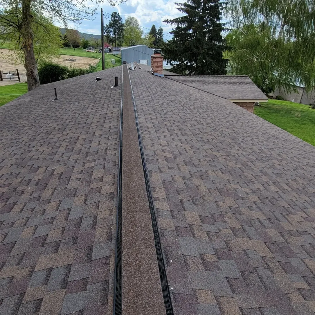 New architectural shingle roof with fresh ridge vent after reroof